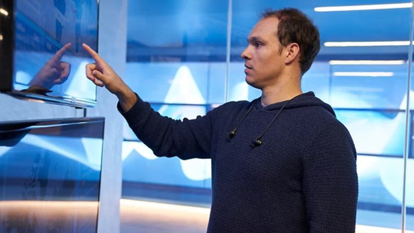 A cybersecurity expert analyzing a graph on a monitor.