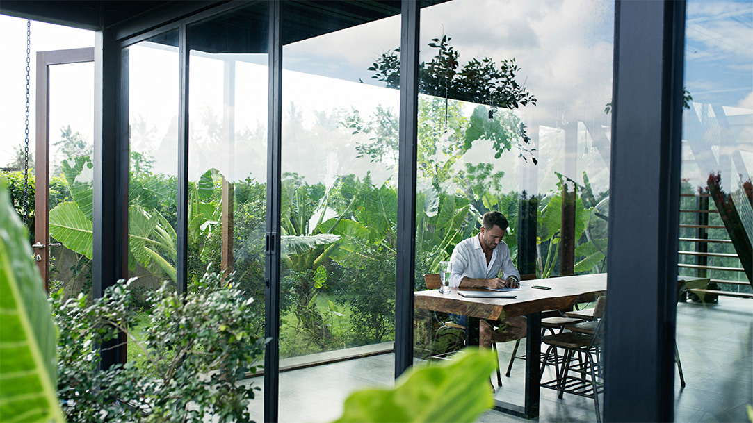 A man sitting at a table in front of a lush spring garden