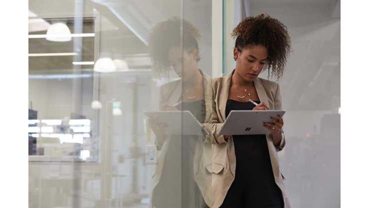Una mujer escribe con el Lápiz para Surface en una tableta Surface