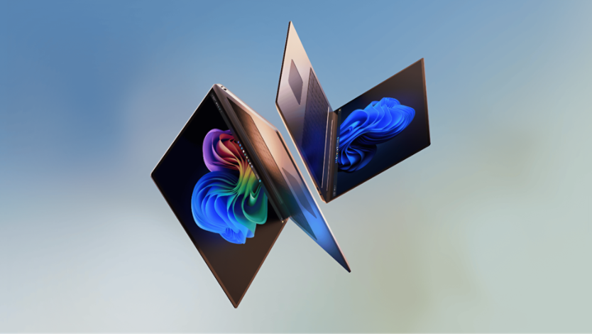 Two sleek, modern laptops with metallic finishes floating mid-air, facing each other set against a blurred blue and green background.
