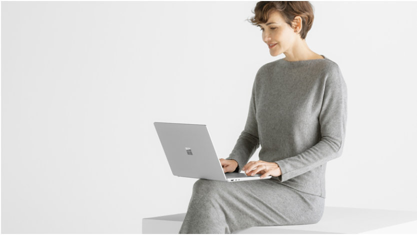 膝の上に Surface Laptop 6 を載せて座る女性