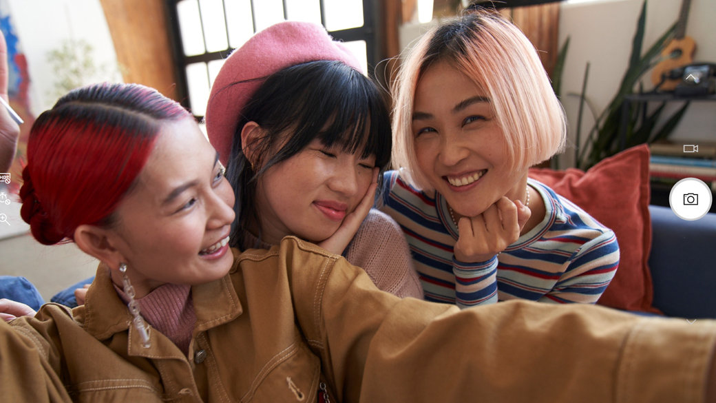 Trois jeunes femmes prenant une photo ou une vidéo