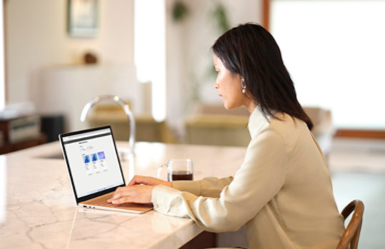 woman working on a laptop from her kitchen island